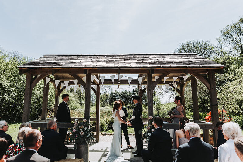 A couple being married under the arbour
