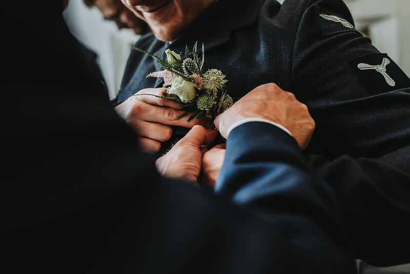 A groomsman having his favor attached