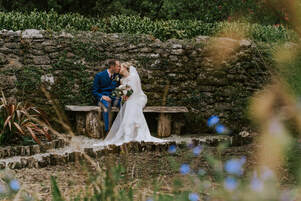 A couple walking round the pond at Knightor following their ceremony