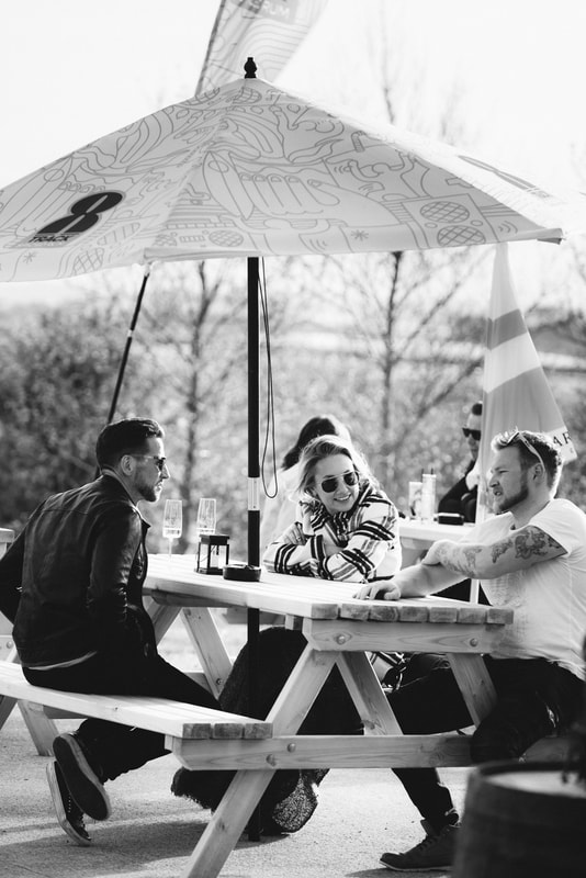 A group of customers enjoying a drink outside at The Vine by Knightor. 